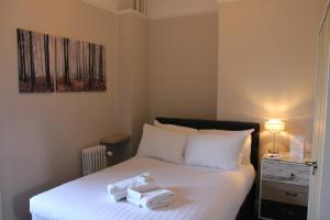 a bedroom with a bed with two towels on it at Eastwood Park Country House in Falfield +13 photos