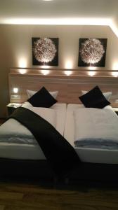 Hotel Lindenhof في فارشتاين: غرفة نوم مع سرير مع وسائد سوداء وبيضاء