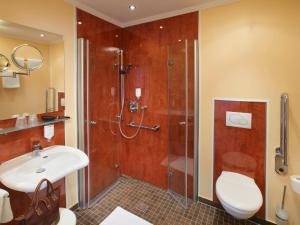 a bathroom with a shower and a sink and a toilet at Hotel Lindenhof in Warstein