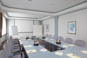 una sala de conferencias con una mesa larga y sillas en Hotel Lindenhof, en Warstein