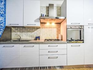 a kitchen with white cabinets and a brick wall at Apartment Antony by Interhome in Rosapineta