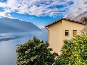 a house with a view of the water and mountains at Apartment Miralago by Interhome in Oria