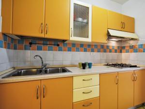 a kitchen with yellow cabinets and a sink at Apartment Solmare-52 by Interhome in Rosapineta