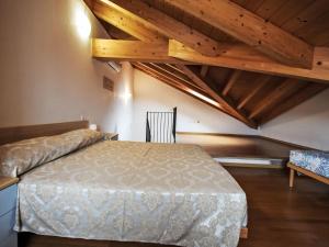 a bedroom with a bed in a room with wooden ceilings at Apartment Solmare-52 by Interhome in Rosapineta