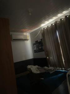Habitación pequeña con cama y cortina en Vida Gamer, en Feira de Santana