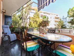 un patio avec une table et des chaises sur un balcon dans l'établissement 100mq Deluxe Apt - Walk to Beach - Private Parking, à Sanremo