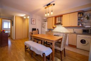 a kitchen with a wooden table and a dining room at Rincón de Tramacastilla de Tena in Tramacastilla de Tena