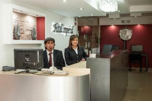 a man and woman standing at a counter in a salon at Hotel Imperial in Ambato