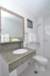 a bathroom with a sink and a toilet and a mirror at 717 Cesar Place Hotel in Tagbilaran City