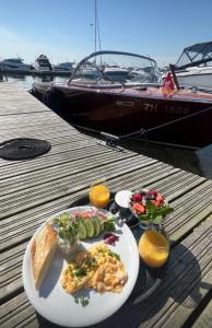 a plate of food on a dock with a boat at Sopot Classic Boat in Sopot