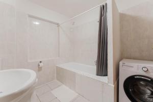 a white bathroom with a washing machine and a washer at feworld living - Wasserwald Linz in Linz +13 photos