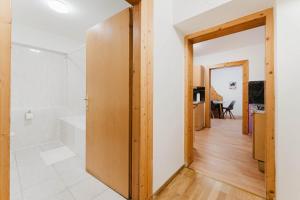 a bathroom with a tub and a toilet in a room at feworld living - Wasserwald Linz in Linz