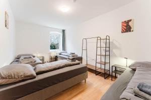 a living room with two beds and a shelf at feworld living - Wasserwald Linz in Linz