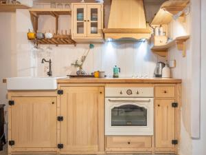 a kitchen with wooden cabinets and a sink and an oven at Holiday Home Amorino by Interhome in Cres