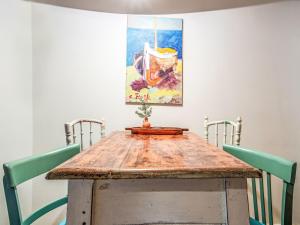 a wooden table with two chairs and a painting on the wall at Holiday Home Amorino by Interhome in Cres