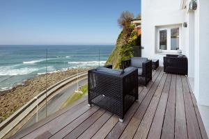 een balkon met stoelen en uitzicht op de oceaan bij Saiaz Getaria Hotela in Getaria
