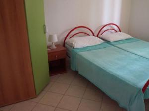 a bedroom with two beds and a night stand with a lamp at Berta in Rosolina