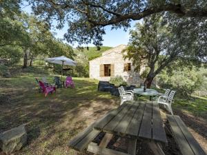 una mesa de picnic y sillas frente a una casa de piedra en Holiday Home Casa Gialla by Interhome, en Arraggio