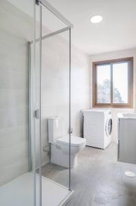 a bathroom with a toilet and a glass shower stall at New Apartment With Stunning Views in Mijas