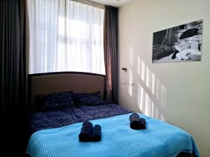une chambre avec un lit avec des chaussures dessus dans l'établissement City Center 2BDR apartment near Rustaveli Av., à Tbilissi 43 autres photos