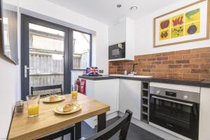 a kitchen with a wooden table with two glasses of orange juice at Pitts Cottage Annexe in Bladon
