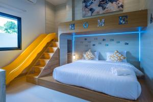 a bedroom with a large bed and a yellow slide at Mada pool villa near Aonang beach in Ban Chong Phli