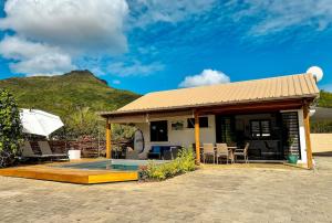 a house with a patio and a swimming pool at Cottage for Couples with Pool, BBQ and views in Tamarin