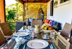 a table with plates of food on a patio at Cottage for Couples with Pool, BBQ and views in Tamarin