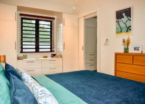 a bedroom with a bed and a dresser and a window at Cottage for Couples with Pool, BBQ and views in Tamarin