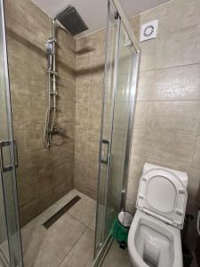 a bathroom with a toilet and a glass shower at Golden Lux Apartments in Skopje +49 photos