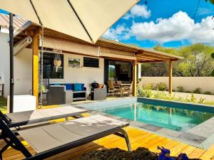 a house with a swimming pool and a patio at Cottage for Couples with Pool, BBQ and views in Tamarin