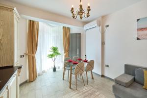 een eetkamer met een tafel en stoelen in een kamer bij Anda Apartment Spa Pool beach resort in Mamaia