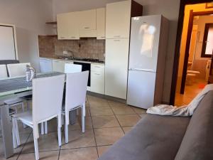 a kitchen with a table and a white refrigerator at Dalia House - Key to Villas in Valledoria +22 photos