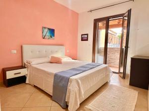 a bedroom with a bed and a large window at Dalia House - Key to Villas in Valledoria