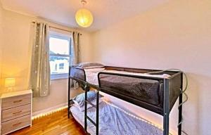 ein Schlafzimmer mit zwei Etagenbetten und einem Fenster in der Unterkunft Kanangra, 2 bedroom apartment in Teignmouth in Teignmouth