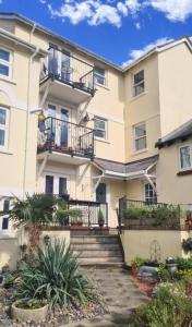 ein Apartmenthaus mit einer Treppe davor in der Unterkunft Kanangra, 2 bedroom apartment in Teignmouth in Teignmouth