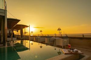a pool with the sunset in the background at Palazzo del Corso – Boutique Hotel in Gallipoli
