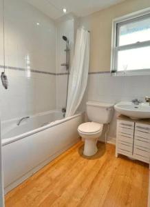 ein Badezimmer mit Toilette, Badewanne und Waschbecken in der Unterkunft Kanangra, 2 bedroom apartment in Teignmouth in Teignmouth