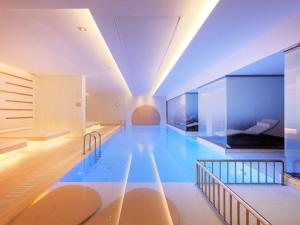 a large swimming pool in a building with blue water at Novotel Istanbul Bosphorus Hotel in Istanbul +37 photos