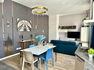 a living room with a table and blue chairs at Milano Duomo Design Apartment in Milan