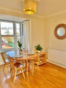 ein Esszimmer mit Tisch und Stühlen und einem Fenster in der Unterkunft Kanangra, 2 bedroom apartment in Teignmouth in Teignmouth