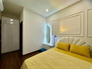 a bedroom with a large bed with a yellow blanket at Căn Hộ 2 Phòng ngủ LUXURY-1516 in Gia Lâm Pho