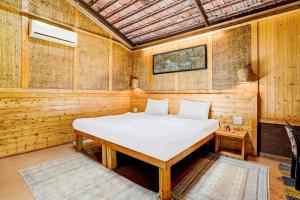 a bedroom with a bed in a wooden room at Palette Palghar Irayos Resort Lifestyle Retreat in Talāsri