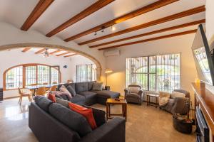 a living room with a couch and a tv at VILLA HERBEN JAVEA - Golf Club Jávea in Jávea