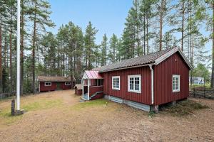 a small red building in a field with trees at Nice ski in ski out cabin in Bollnäs