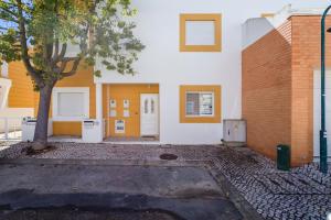 a building with a tree in front of it at TAC - Serenity Manta Rota in Vila Nova De Cacela