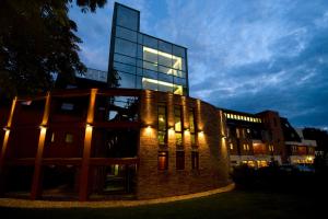 a brick building with a tall glass building at Holiday Beach Budapest Wellness Hotel with Sauna Park in Budapest