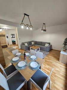 una sala de estar con una mesa, sillas y un sofá en AB Apartman Zlatibor, en Zlatibor