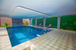 a swimming pool with two chairs next to a building at Paradise Court by LLA in Accra