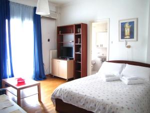 a bedroom with a bed and a television in it at Athens Quality Apartments in Athens